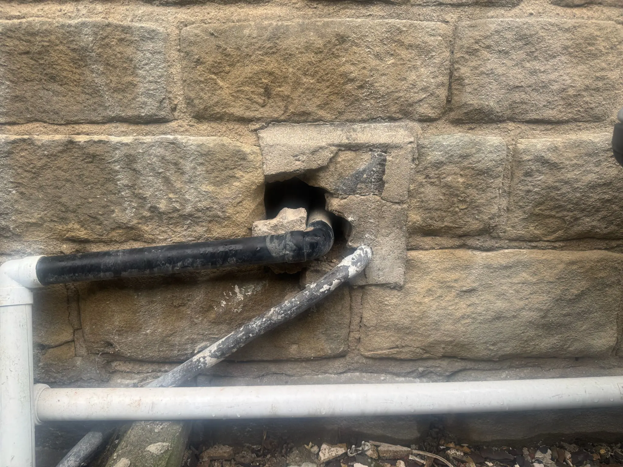 Rat entry point where waste pipes pass through a building wall on a Sheffield property